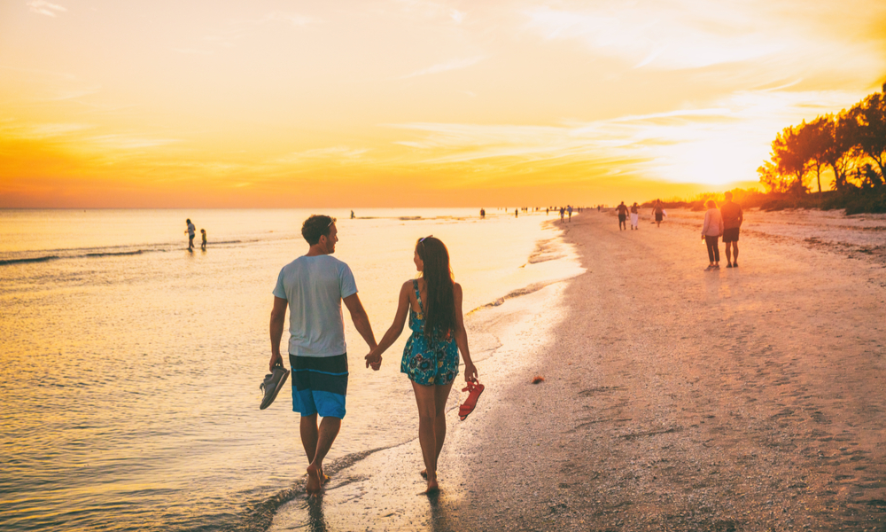 6 Under-the-Radar Romantic Getaways: A couple walks on the beach during sunset on Sanibel Island, FL