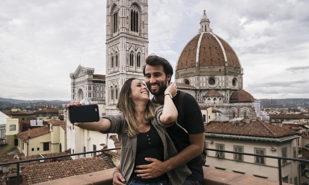 The most romantic places in Italy: Young lovers visiting Florence in Italy and taking a selfie