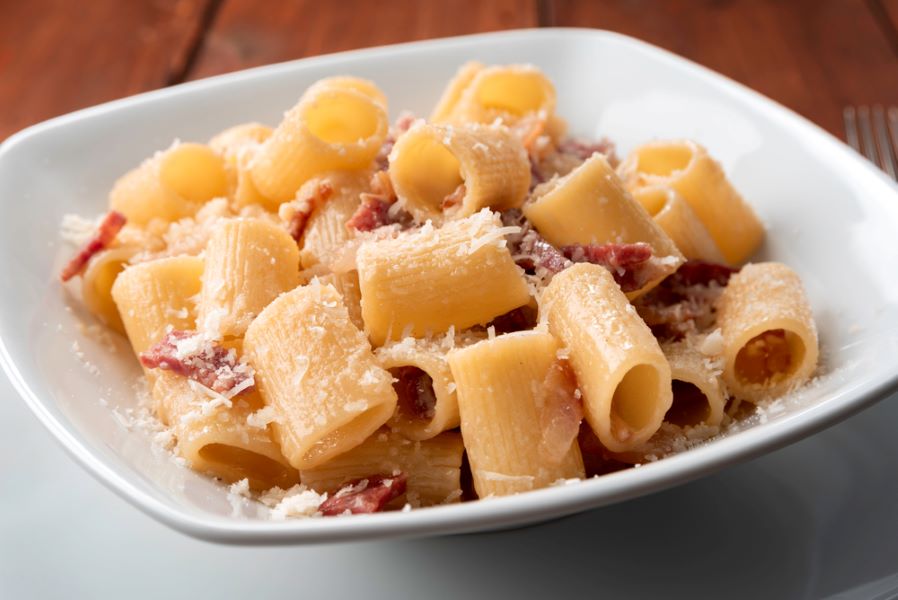 Maccheroni alla gricia, plate of delicious italian pasta with guanciale and pecorino, typical italian and roman food