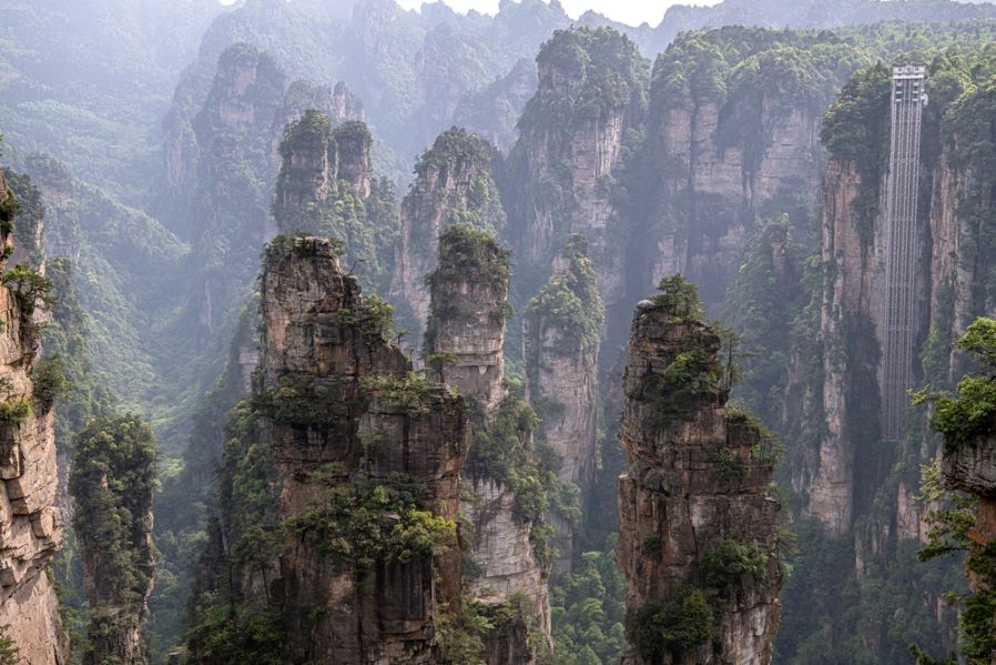 Karst rock formations and Bailong elevator during the sunset in Laowuchang spot of Wulingyuan Scenic Area, Zhangjiajie, Hunan, China. Copy space for text, wallpaper and background