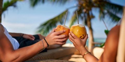 Couple drinking coconuts on the beach