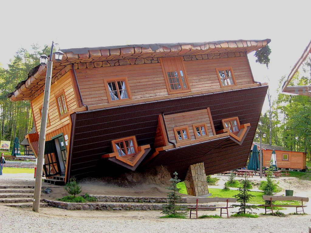 English: An 'upside-down house' in an open-air museum (The Education and Region Promotion Centre) in Szybmark, northern Poland. The interior of the two-floor building (furniture, stairs, objects) is set upside-down as well, ie. is glued to the ceiling. Persons with inner-ear or balance disabilities are discouraged from entering the structure