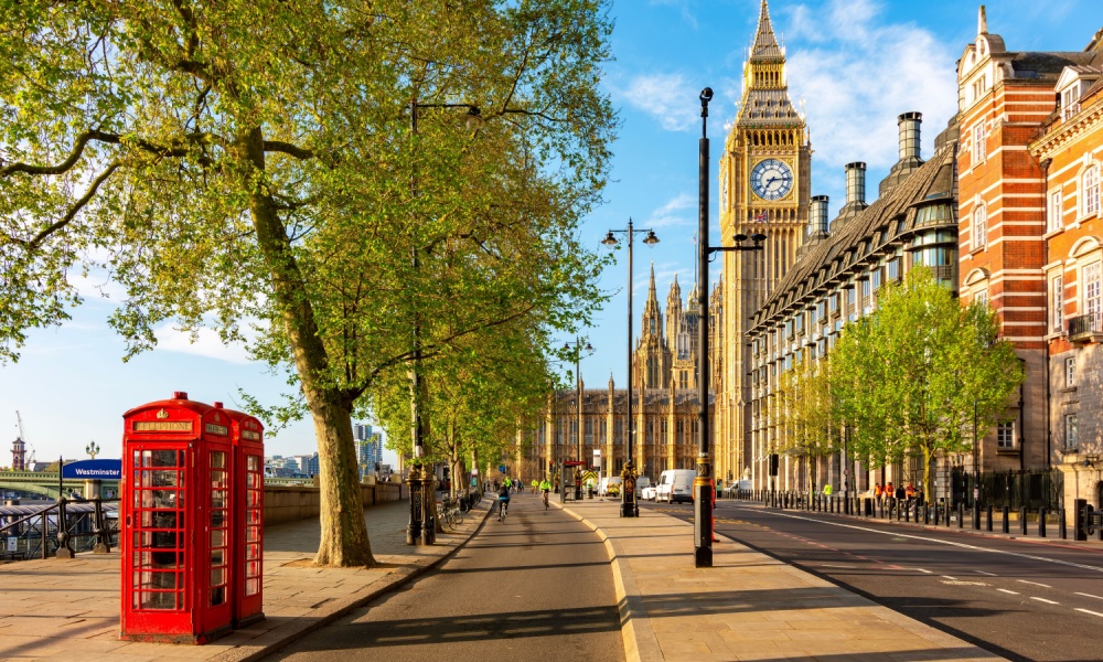 Red telephone boxes on Victoria embankment and Big Ben tower, London, UK