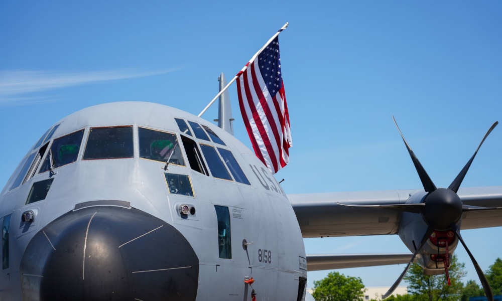 The flag of America is hanging over a military airplane part of the US Air Force