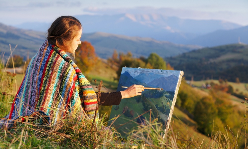 Woman painting mountains