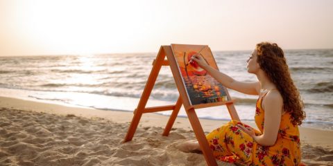 Woman painting on the beach